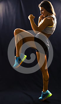 Strong sports woman doing a knee kick