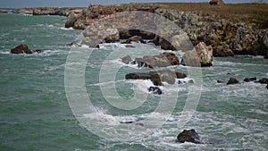 Strong storm near a rocky coast, white waves with foam in the sea, Black Sea, Bulgaria