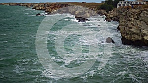 Strong storm near a rocky coast, white waves with foam in the sea, Black Sea, Bulgaria