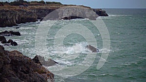 Strong storm near a rocky coast, white waves with foam in the sea, Black Sea, Bulgaria