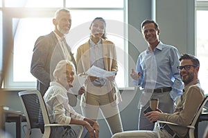 Strong and successful team. Group of happy multiracial business people smiling at camera while having a meeting at