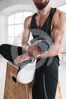 Strong sweaty man sitting at box and hold towel in hands