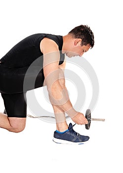 Exercising man tying his shoe laces