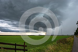 Strong thunderstorm with hail shaft over the green dutch countryside