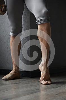 Strong trained legs of male ballet dancer cropped shot