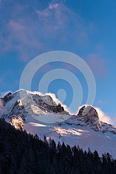 Strong wind blowing clouds over alpine peaks in winter