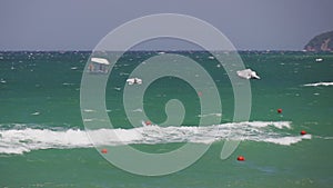 A strong wind blowing over the blue-green Mediterranean sea with powerboats and motorboats on waves