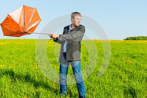 Strong wind wrenched umbrella man