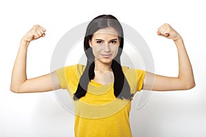 Strong woman. Beautiful girl showing her muscularity, looking at camera