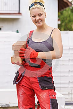 Strong woman building using bricks