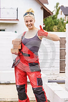 Strong woman building using bricks