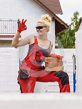 Strong woman building using bricks