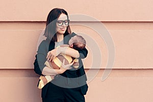 Strong Woman in Business Outfit Holding Baby