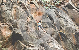 Strong woman climbing a rock wall in a canyon - Climber training outdoor - Travel, adrenaline and extreme dangerous sport concept