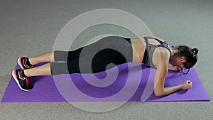 Strong woman doing plank exercise to strengthen muscles and have perfect body