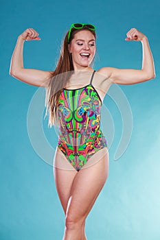 Strong woman girl in swimsuit showing off muscles.