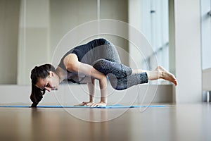 Strong woman performing eight-angle pose