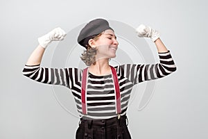 Strong woman showing her muscularity. Funny mime showing her power