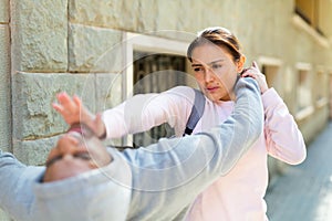 Strong woman using forceful blow in the eyes of rapist on street