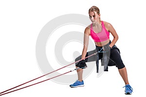 Strong woman using a resistance band in her exercise routine. Young woman performs fitness exercises on white background