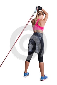 Strong woman using a resistance band in her exercise routine. Young woman performs fitness exercises on white background