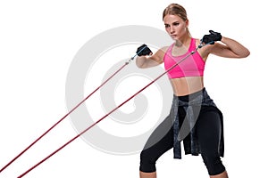 Strong woman using a resistance band in her exercise routine. Young woman performs fitness exercises on white background