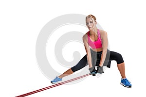 Strong woman using a resistance band in her exercise routine. Young woman performs fitness exercises on white background