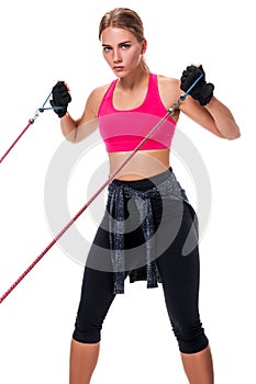 Strong woman using a resistance band in her exercise routine. Young woman performs fitness exercises on white background