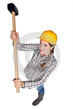 Strong woman using sledgehammer