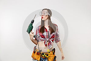 Strong young energy handyman woman in plaid top shirt denim shorts kit tools belt full of instruments in protective