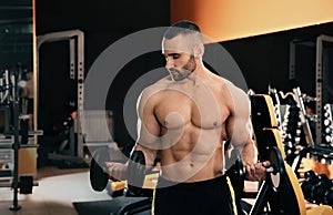 Strong young man lifting dumbbells