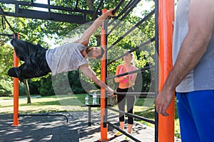 Strong young man practicing human flag exercise with bent legs