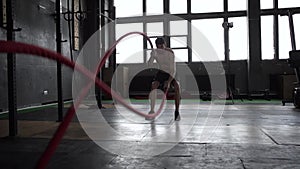 Strong young man training with battle ropes