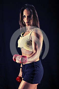 Strong young woman doing bicep curls