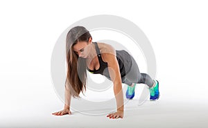 Strong young woman doing push-ups. Fit female exercising in health club