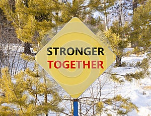 Stronger together symbol. Concept words Stronger together on beautiful yellow road sign. Beautiful forest snow blue sky background