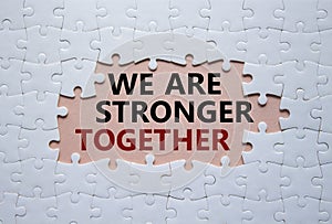 We are stronger together symbol. White puzzle with words We are stronger together. Beautiful pink background. We are stronger