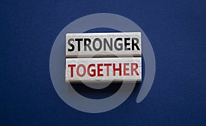 Stronger together symbol. Wooden blocks with words Stronger together. Beautiful deep blue background. Stronger together concept.