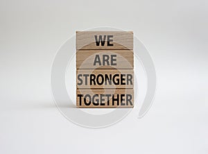 We are stronger together symbol. Wooden blocks with words We are stronger together. Beautiful white background. We are stronger