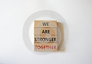 We are stronger together symbol. Wooden blocks with words We are stronger together. Beautiful white background. We are stronger