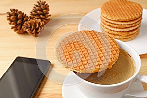 Stroopwafel Placed on Hot Coffee Cup with a Cellphone