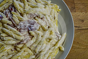 Strozzapreti cream and speck, specialty from northern Italy, fresh twisted pasta with sauce made of fresh cream and speck