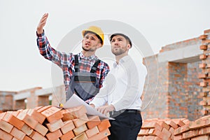 Structural engineer and foreman worker discuss, plan working for the outdoors building construction site