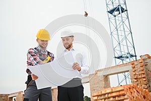 Structural engineer and foreman worker discuss, plan working for the outdoors building construction site