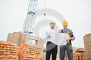 Structural engineer and foreman worker discuss, plan working for the outdoors building construction site