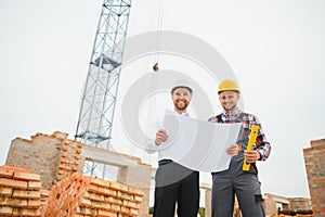 Structural engineer and foreman worker discuss, plan working for the outdoors building construction site