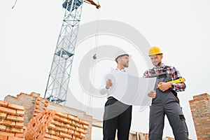 Structural engineer and foreman worker discuss, plan working for the outdoors building construction site