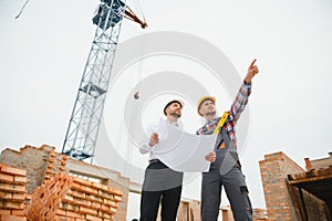 Structural engineer and foreman worker discuss, plan working for the outdoors building construction site