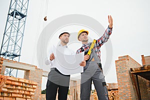 Structural engineer and foreman worker discuss, plan working for the outdoors building construction site