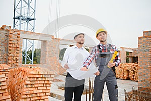 Structural engineer and foreman worker discuss, plan working for the outdoors building construction site